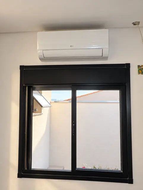 Split LG instalado sobre janela de esquadria preta