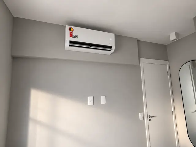 Split no alto da parede de um quarto com parede cinza